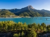 Summer panoramic view of Serre-Poncon Lake with Savines-le-Lac, its bridge and the Grand Morgon mountain peak. Hautes-Alpes, PACA Region, Southern French Alps, France