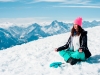 Beautiful young woman doing yoga in the snow mountain